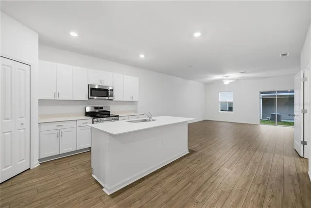 a kitchen with stainless steel appliances a white stove top oven sink and cabinets
