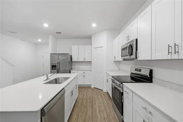 a kitchen with a sink a stove and refrigerator