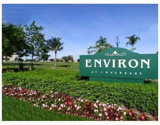 a sign of golf club on a wall under a tree