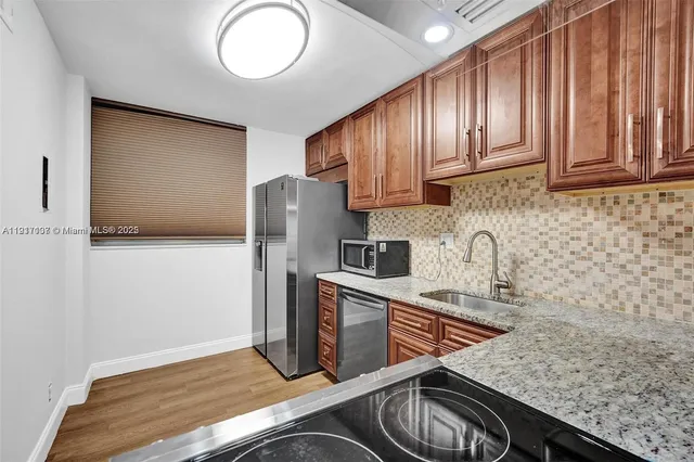 a kitchen with stainless steel appliances granite countertop a sink stove and refrigerator