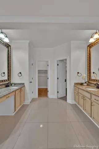 a large bathroom with a granite countertop double vanity sink a mirror and a bathtub
