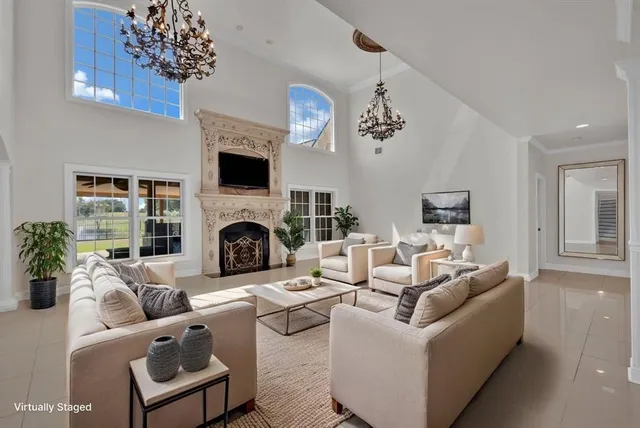 a living room with furniture a fireplace and a chandelier