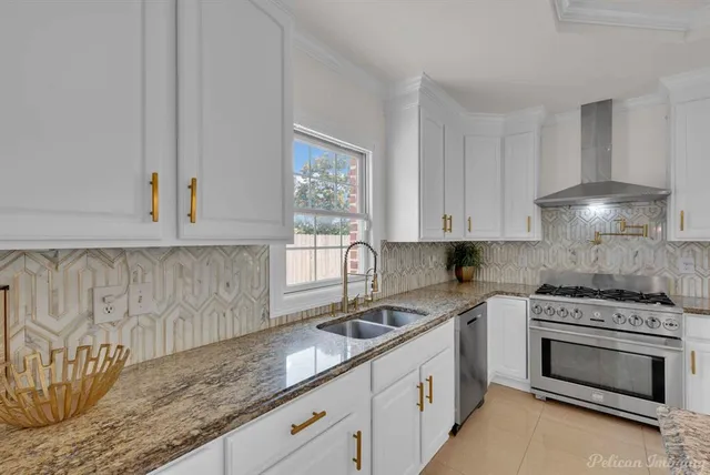 a kitchen with granite countertop a sink a stove and cabinets