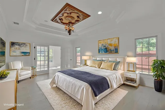 a spacious bedroom with a large bed and a chandelier