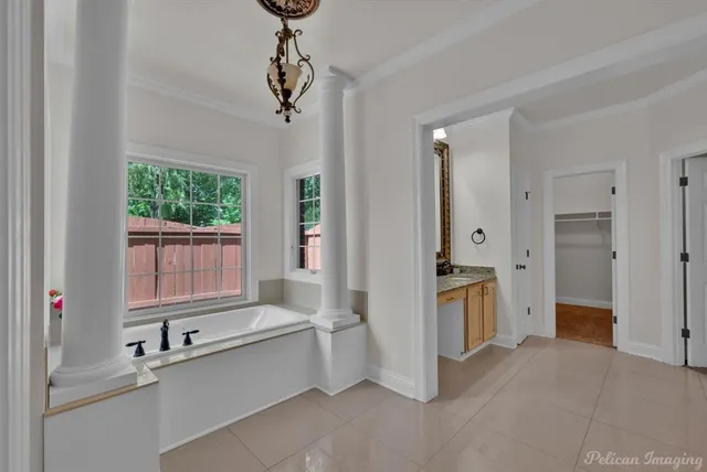 a large white kitchen with granite countertop a refrigerator and a sink