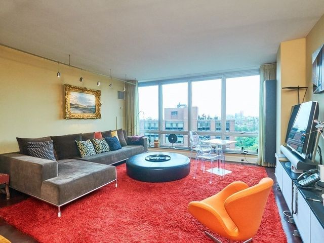 a living room with furniture a rug and a large window