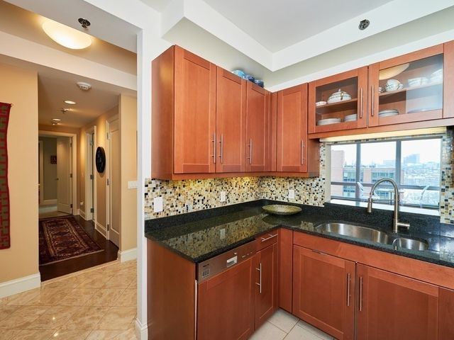 a kitchen with granite countertop sink and cabinets