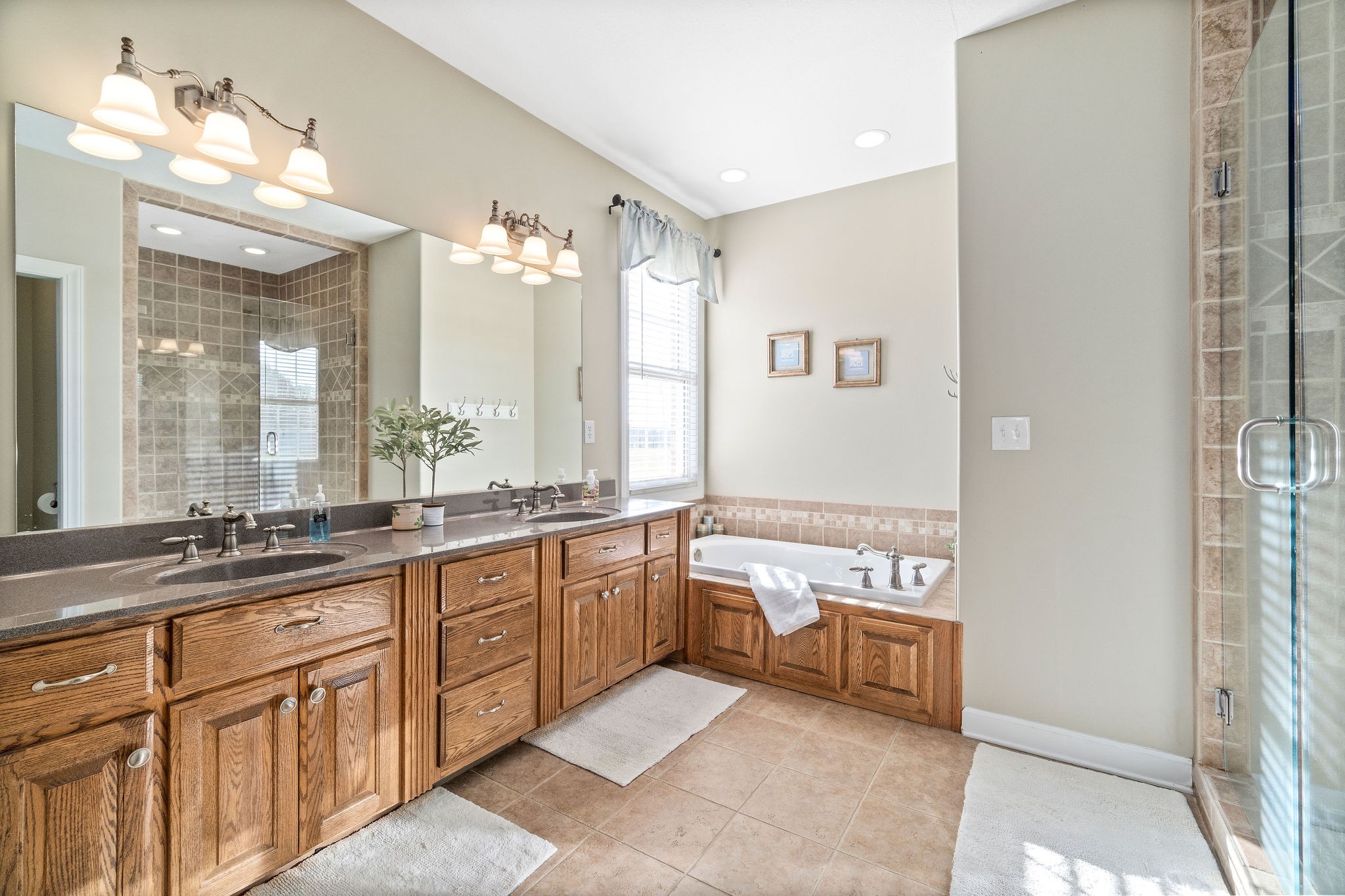 1488 Cooley Ford Road Tennessee Ridge, TN 37178 - Photo 24 of 46 a large bathroom with a double vanity sink a large mirror and a bathtub