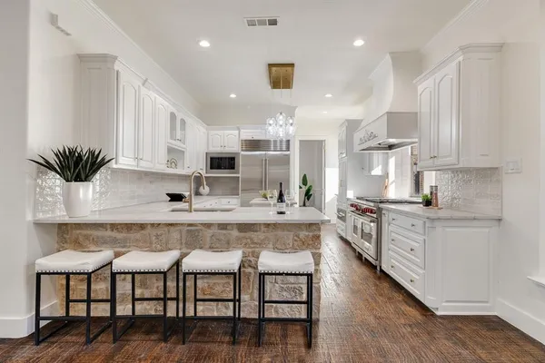 a large kitchen with cabinets table and chairs