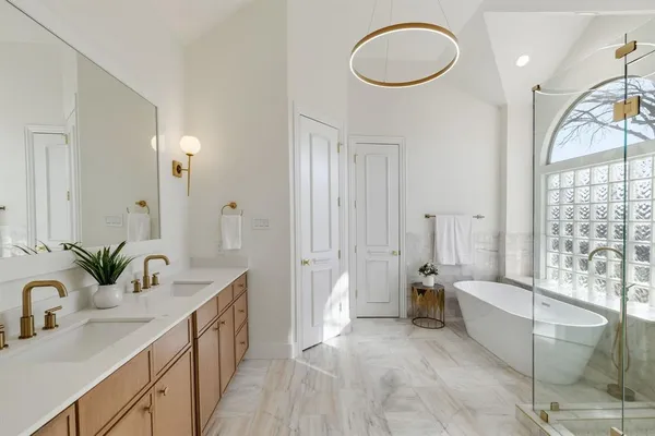 a spacious bathroom with a double vanity sink a mirror and a bathtub