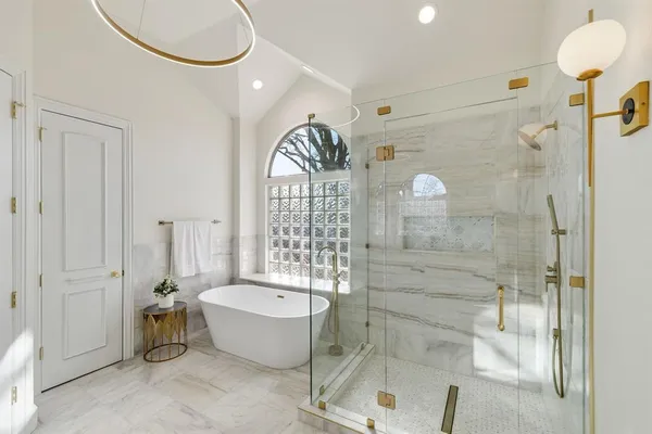 a bathroom with a tub a double vanity sink and a mirror