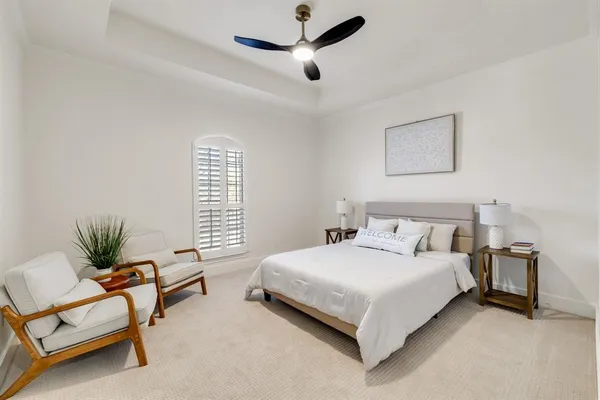 a bedroom with a bed a couch and a potted plant
