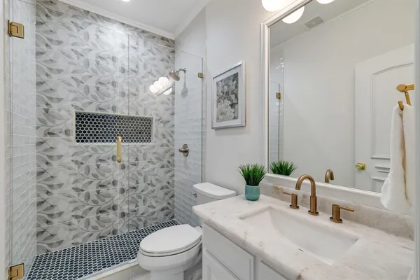 a bathroom with a sink a toilet and shower