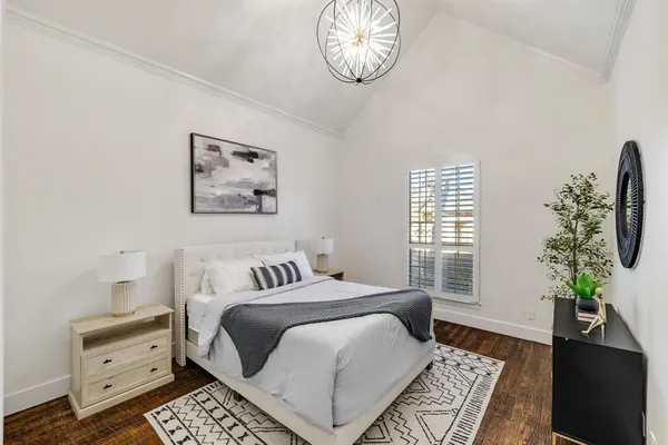 a bedroom with a bed and a potted plant