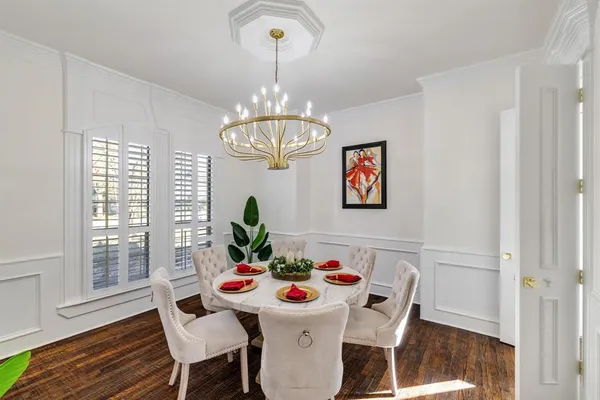 a view of a dining room with furniture a chandelier and wooden floor