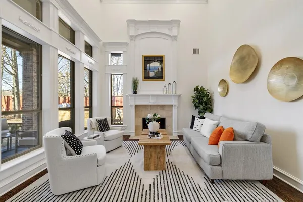 a living room with furniture fireplace and a large window