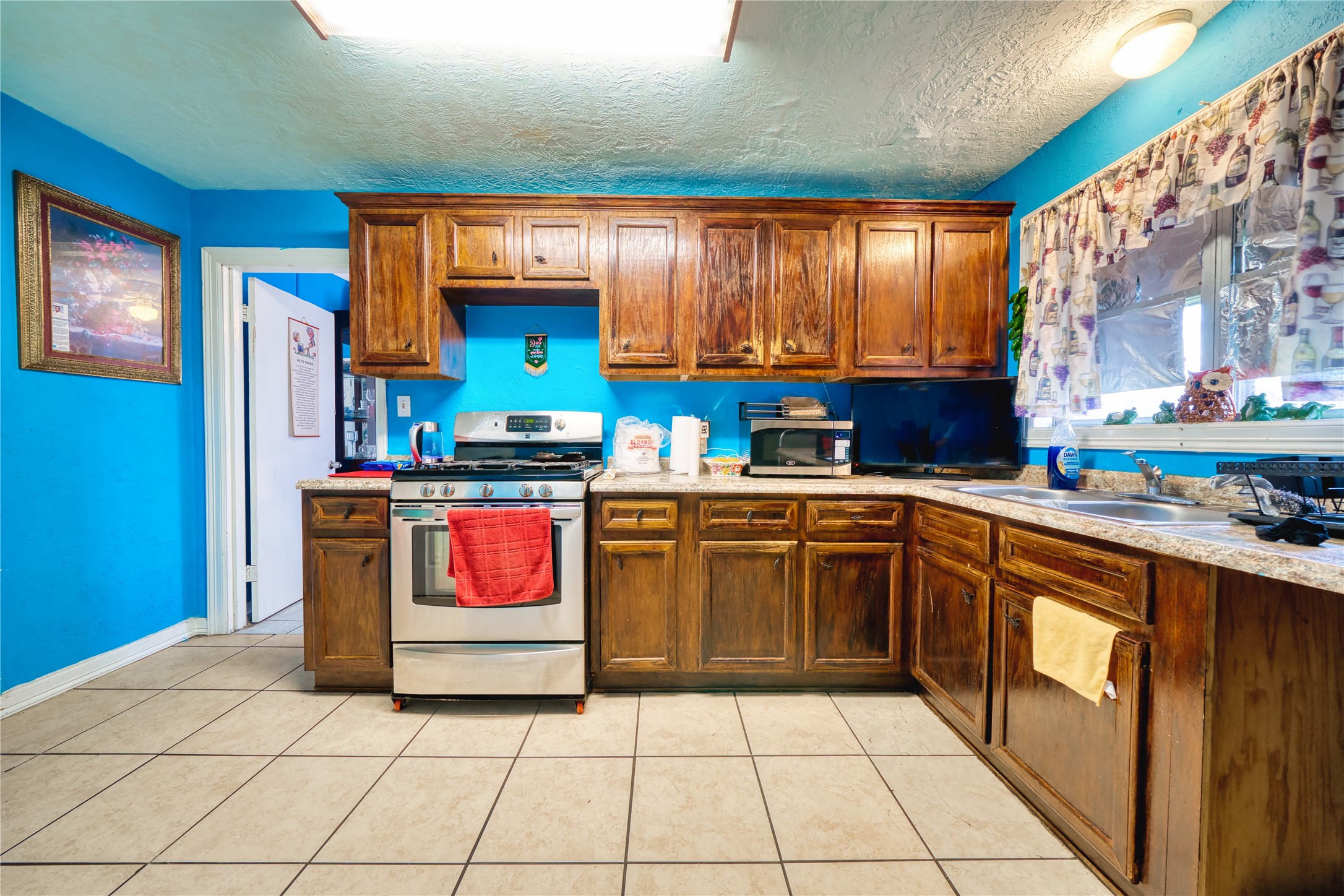4931 Mercedes Lane Houston, TX 77022 - Photo 12 of 29 a kitchen with stainless steel appliances granite countertop a stove a sink and a microwave