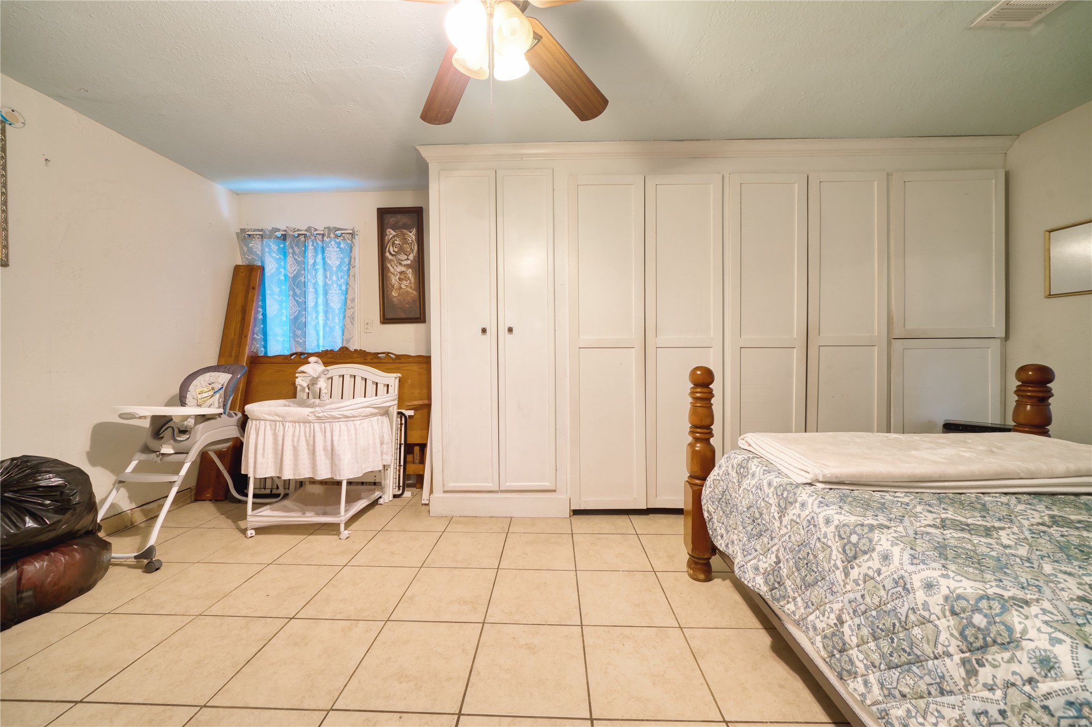 4931 Mercedes Lane Houston, TX 77022 - Photo 25 of 29 a bedroom with a bed and a chandelier
