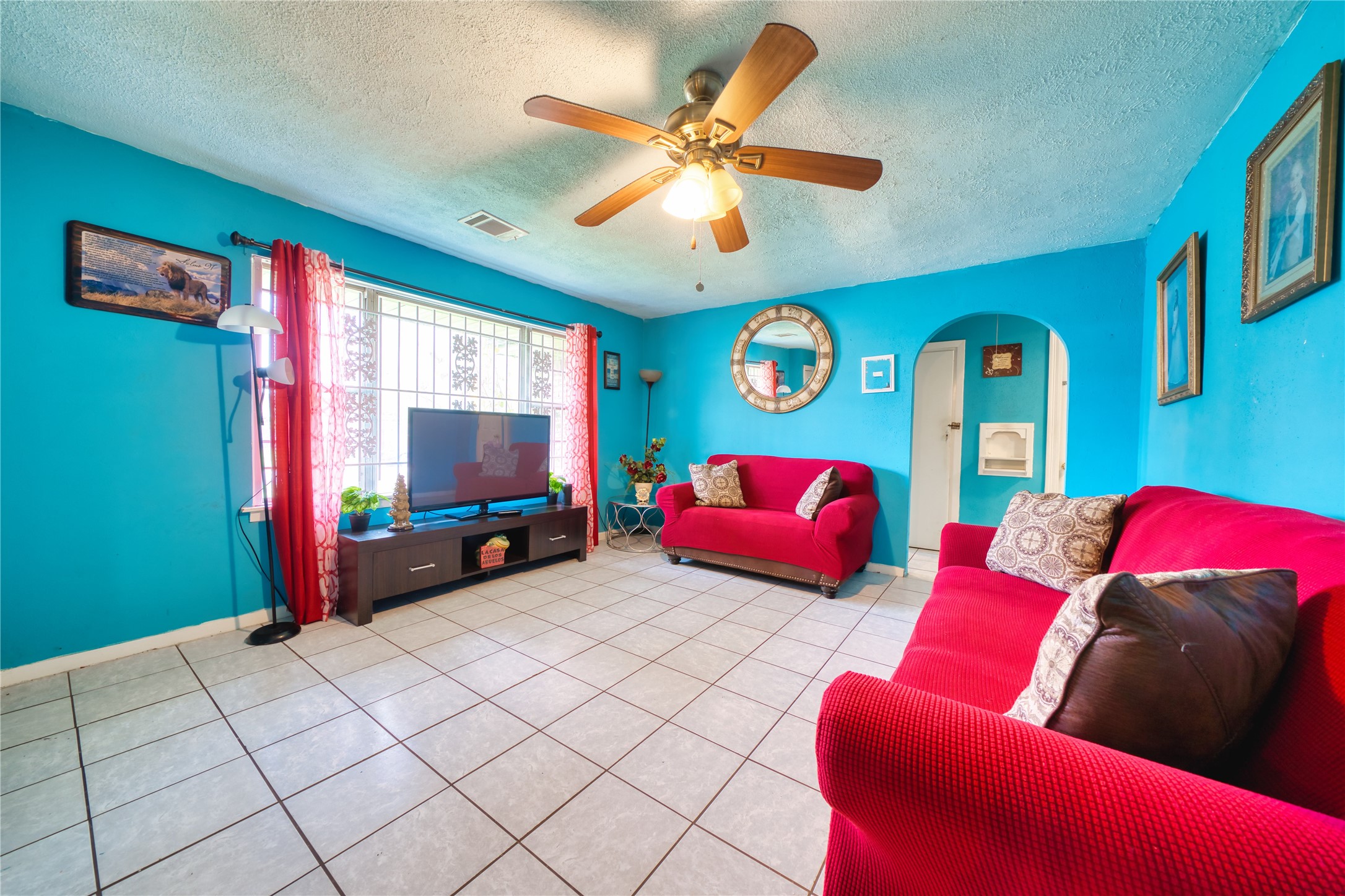 4931 Mercedes Lane Houston, TX 77022 - Photo 8 of 29 a living room with furniture a flat screen tv and a large window
