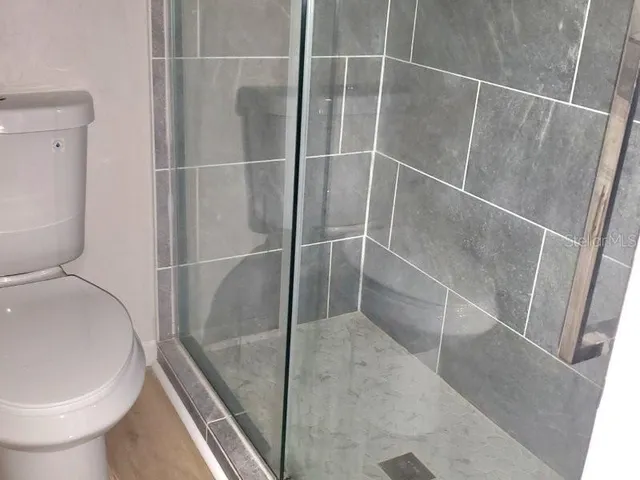a bathroom with a toilet and a shower