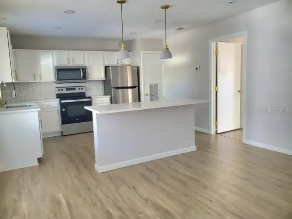 a kitchen with stainless steel appliances granite countertop a refrigerator a stove top oven a sink and dishwasher