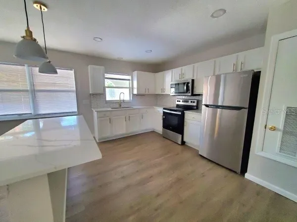 a kitchen with a sink stainless steel appliances and cabinets