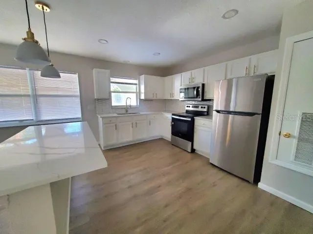 a kitchen with a sink stainless steel appliances and cabinets