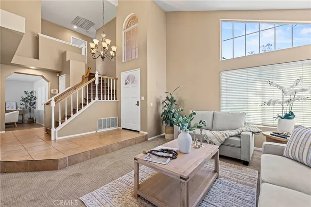 a living room with furniture and a chandelier