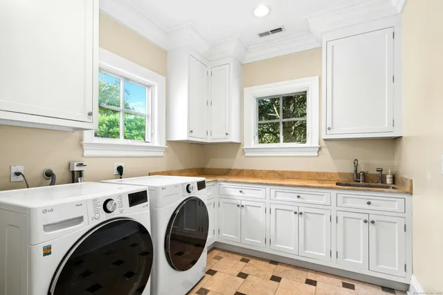 a utility room with sink dryer and washer