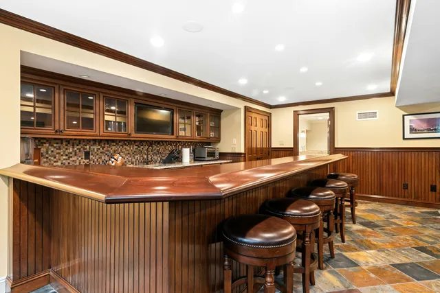 a kitchen with a sink and chairs