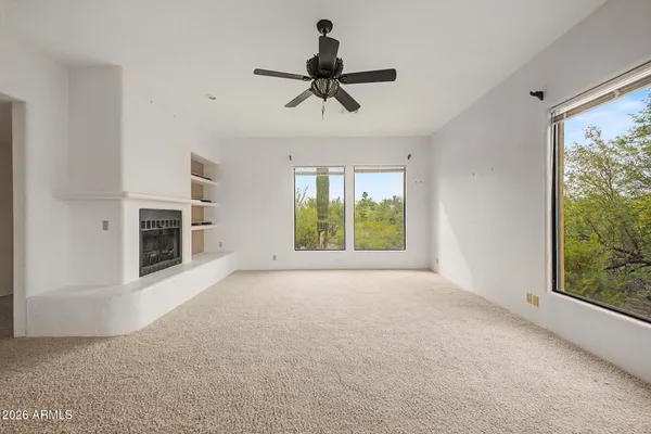 a view of empty room with fireplace and windows