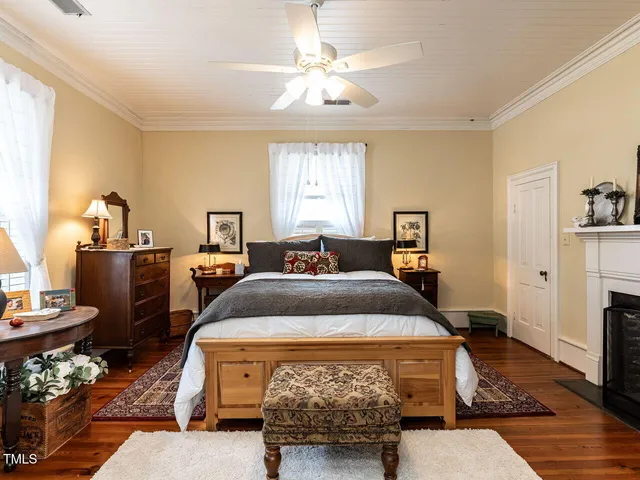a view of a house with a small yard plants and large tree