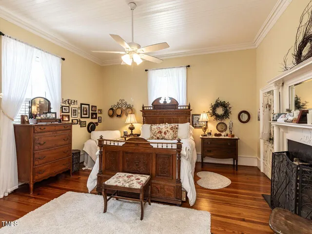 a view of a white house with large windows and flower plants