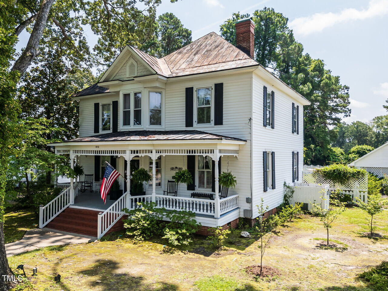 612 College Street Clinton, NC 28328 - Photo 52 of 70 a view of a white house with large windows and a small yard