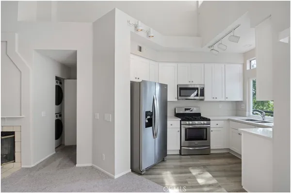 a kitchen with stainless steel appliances granite countertop a refrigerator stove and sink