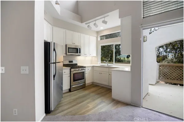 a kitchen with white cabinets and stainless steel appliances