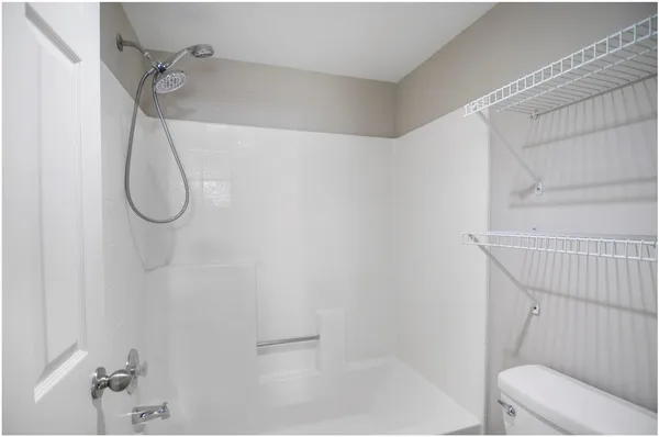 a bathroom with a granite countertop shower and a toilet