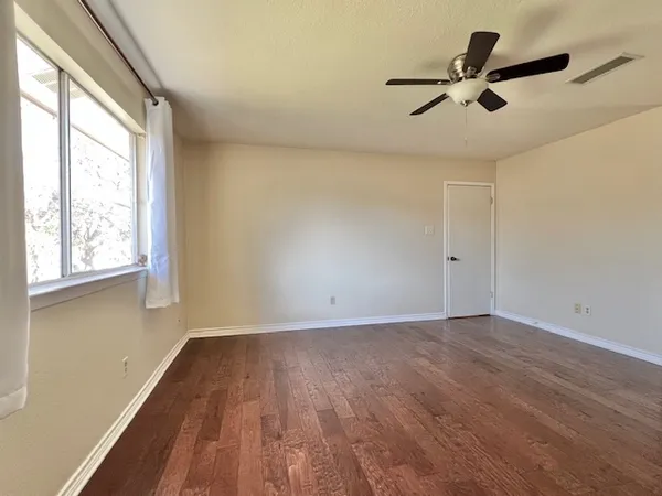 wooden floor in an empty room with a window