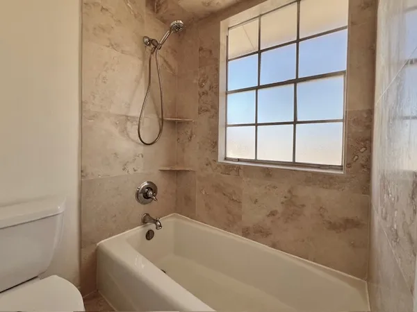 a bathroom with a bath tub with a shower