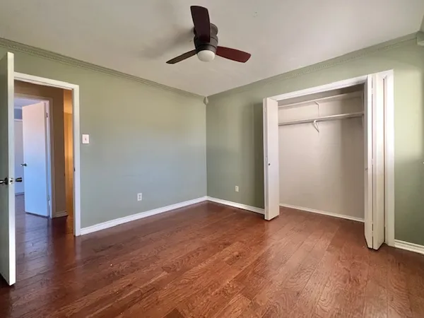 a view of an empty room with wooden floor