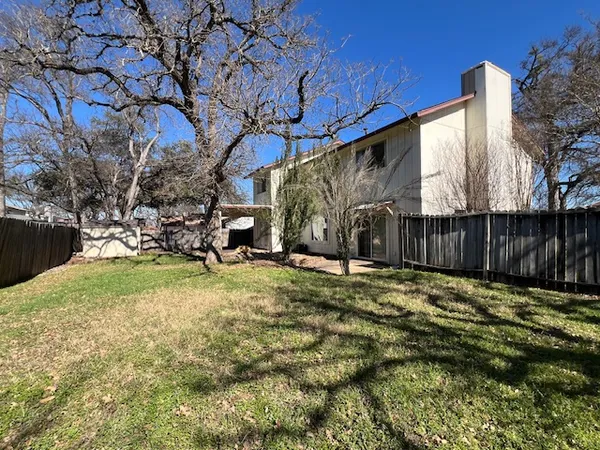 a view of backyard with wooden fence