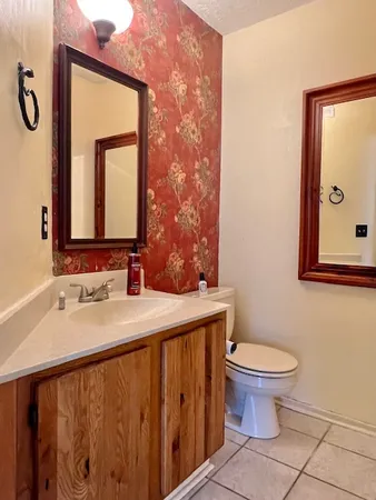 a bathroom with a toilet sink and mirror