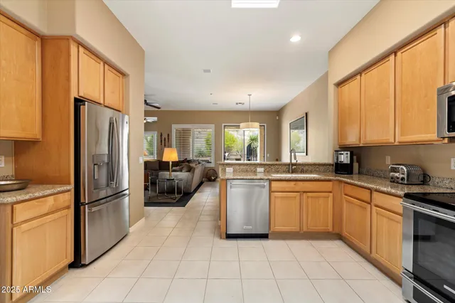 a kitchen with stainless steel appliances granite countertop a refrigerator and a stove top oven