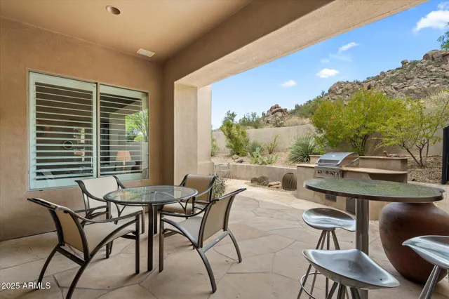 a view of a patio with table and chairs with wooden floor and fence
