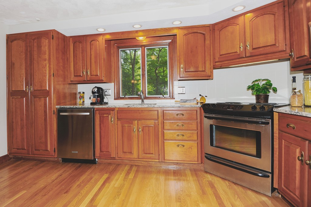 16 Olde Lantern Road Acton, MA 01720 - Photo 7 of 16 a kitchen with granite countertop wooden cabinets stainless steel appliances a sink and a window