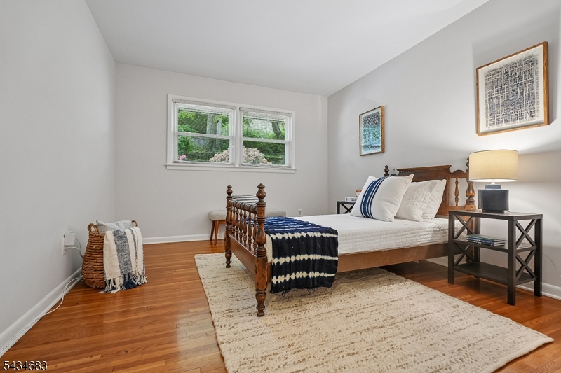 106 Division Avenue Summit, NJ 07901 - Photo 24 of 38 a bedroom with furniture and a wooden floor
