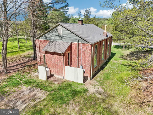 a view of a house with backyard and trees