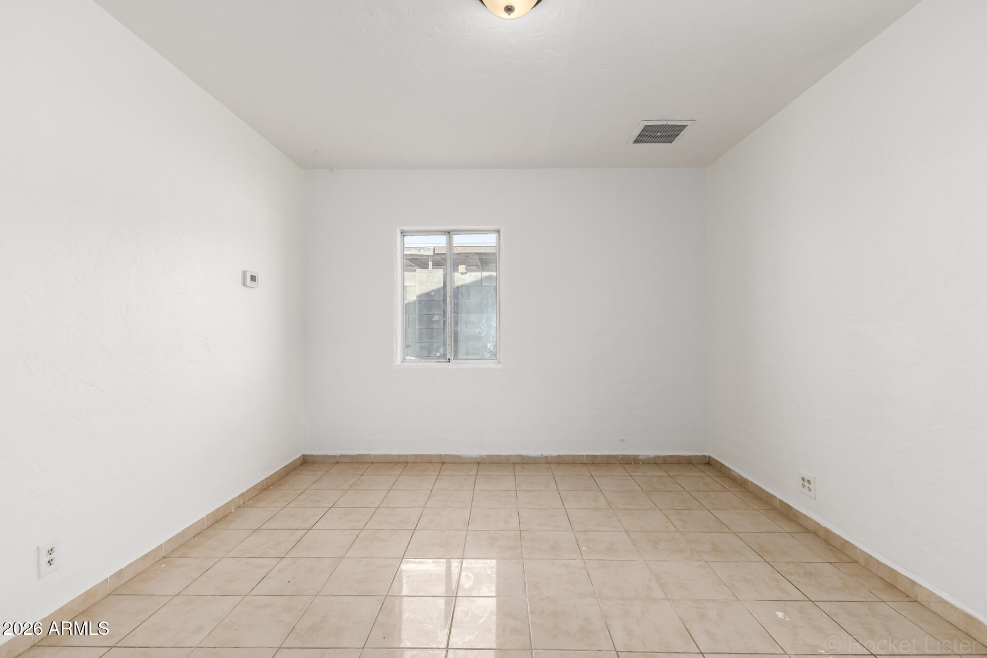 3326 West Culver Street Phoenix, AZ 85009 - Photo 16 of 18 an empty room with a chandeliers