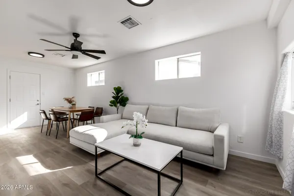 a living room with furniture a table and a potted plant