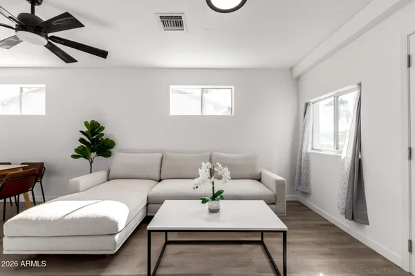 a living room with furniture and wooden floor